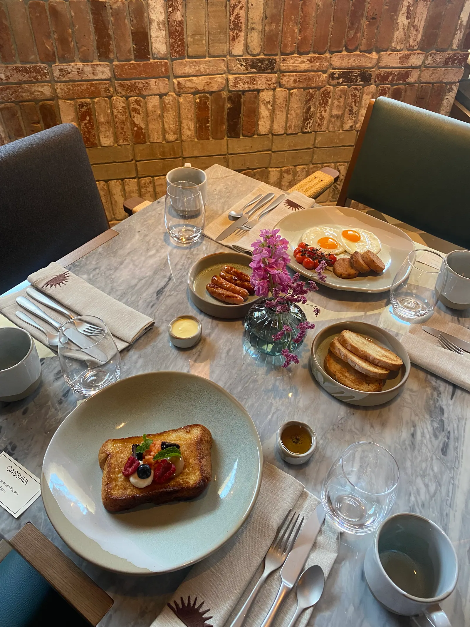 Breakfast table with eggs, toast, fruit and flowers